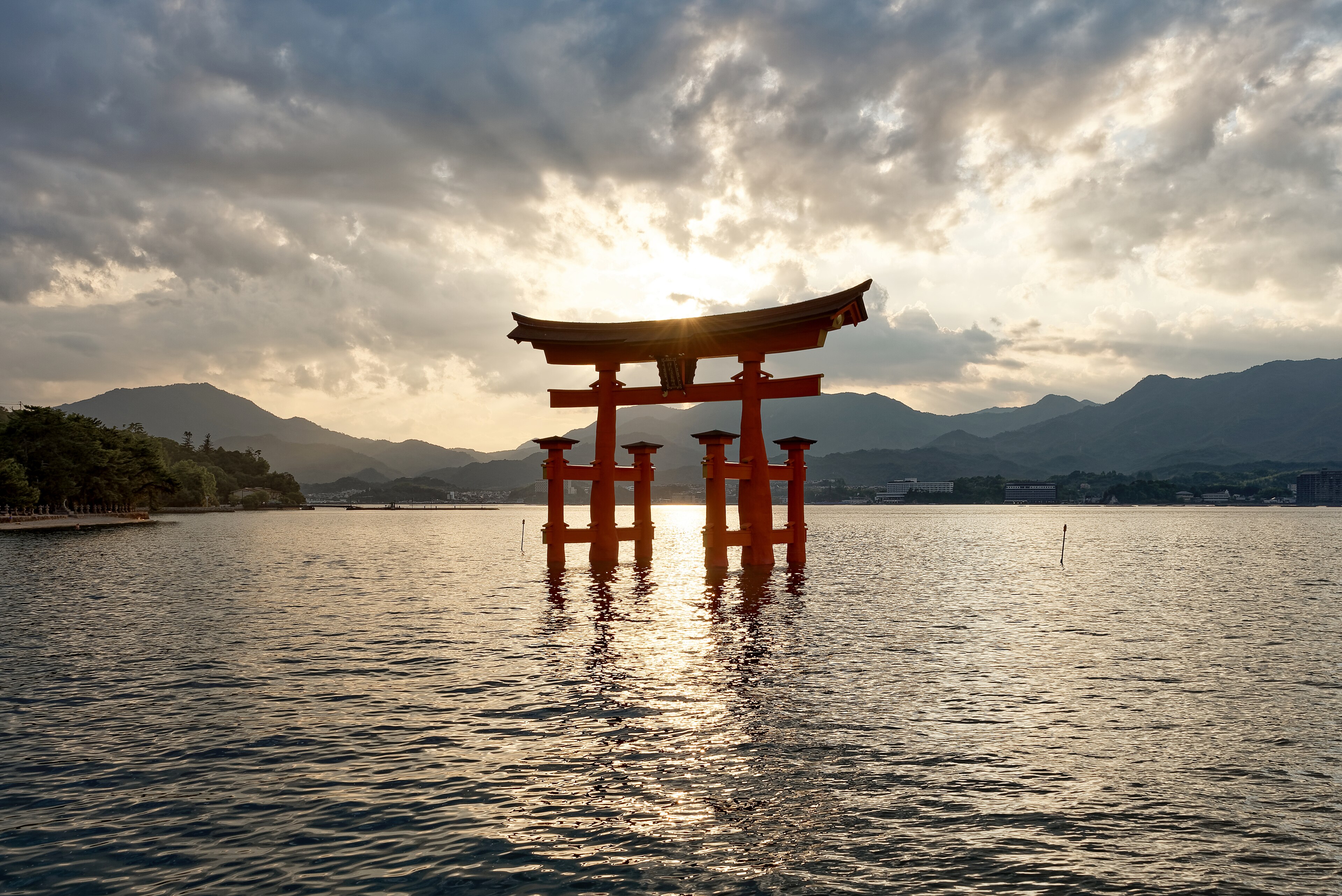 A vermilion torii gate by the water at dusk